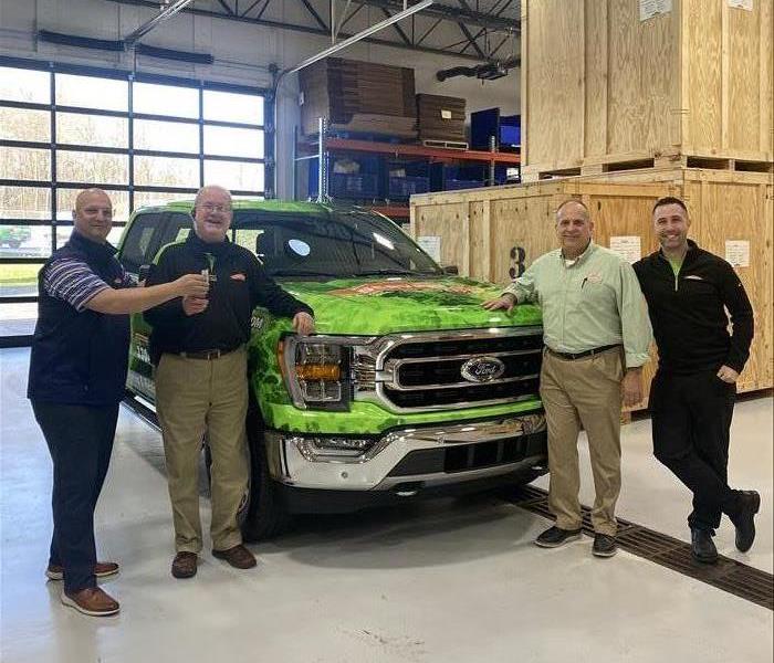 SERVPRO team members pose near a newly wrapped Hybrid Ford F-150