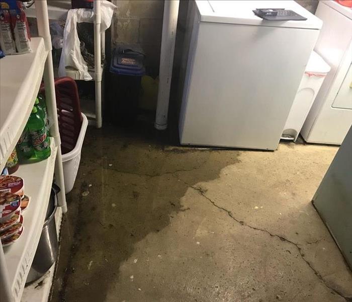 image of visible flooding in an unfinished basement, resulting from a drain overflow