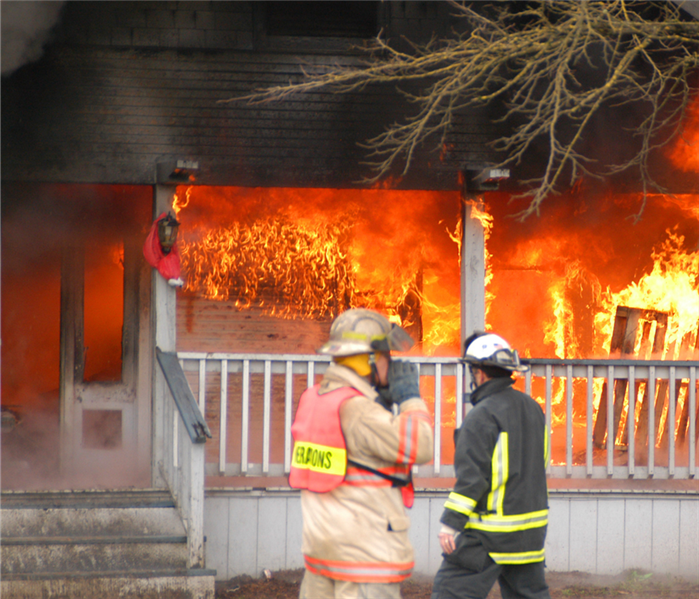 firefighters in front of a burning house